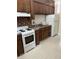 Kitchen with wooden cabinets, white appliances, and brick backsplash at 56 Laurens St, Charleston, SC 29401