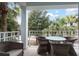 Relaxing balcony with wicker seating, outdoor table, and picturesque views of palm trees at 5800 Palmetto Dr # R-Vg102, Isle of Palms, SC 29451