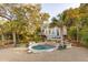 Lovely backyard featuring a pool, spa, lounge chairs, and beautiful landscaping at 608 W Beach Ct, Folly Beach, SC 29439