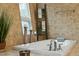 Close up of soaking tub featuring deck-mounted faucet, decor, and a decorative ladder at 608 W Beach Ct, Folly Beach, SC 29439