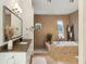 Bathroom with a double sink vanity, soaking tub and large walk-in shower at 608 W Beach Ct, Folly Beach, SC 29439