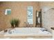 A bright bathroom featuring a soaking tub, decorative accents, and natural lighting at 608 W Beach Ct, Folly Beach, SC 29439