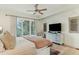 Cozy bedroom featuring a plush bed, dresser, ceiling fan, and natural light from a nearby window at 608 W Beach Ct, Folly Beach, SC 29439