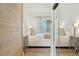 Bedroom with a comfortable bed, serene ambiance, and a view through sliding glass doors at 608 W Beach Ct, Folly Beach, SC 29439