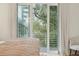 Wooded view from the bedroom balcony with large sliding doors and sheer curtains at 608 W Beach Ct, Folly Beach, SC 29439