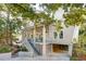Inviting two-story home with a covered porch, charming landscaping, and convenient ground-level parking at 608 W Beach Ct, Folly Beach, SC 29439