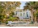 Beautifully designed home exterior featuring multiple decks, lush landscaping, and an inviting pool at 608 W Beach Ct, Folly Beach, SC 29439