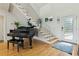 Bright foyer with gleaming hardwood floors, staircase, and a stylish piano, creating an inviting entrance at 608 W Beach Ct, Folly Beach, SC 29439