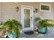 Elegant front door flanked by potted plants, enhancing curb appeal and creating a warm welcome at 608 W Beach Ct, Folly Beach, SC 29439