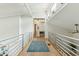 Bright hallway featuring a sleek metal railing, hardwood floors and clerestory windows at 608 W Beach Ct, Folly Beach, SC 29439