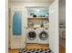 Convenient laundry closet includes washer, dryer, ironing board, and storage shelves at 608 W Beach Ct, Folly Beach, SC 29439