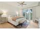 Large main bedroom featuring ceiling fan, ensuite bathroom, and balcony access at 608 W Beach Ct, Folly Beach, SC 29439