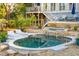 In-ground pool with a stone patio, jacuzzi, and modern exterior at 608 W Beach Ct, Folly Beach, SC 29439