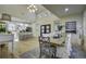 Bright dining area open to kitchen with long wood table, seating, and large windows at 6094 Chisolm Rd, Johns Island, SC 29455