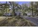 Exterior view showing the home's blue siding, guest house, and ample lot with mature landscaping at 6094 Chisolm Rd, Johns Island, SC 29455
