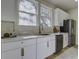 Bright kitchen with white cabinets, quartz counters, a stainless fridge, and updated finishes at 6094 Chisolm Rd, Johns Island, SC 29455