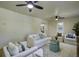 Bright living room offers white sofas, wood floors, ceiling fans and natural light from large windows at 6094 Chisolm Rd, Johns Island, SC 29455