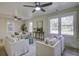 Bright living room offers white sofas, wood floors, ceiling fans and natural light from large windows at 6094 Chisolm Rd, Johns Island, SC 29455