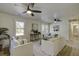 Bright living room offers white sofas, wood floors, ceiling fans and natural light from large windows at 6094 Chisolm Rd, Johns Island, SC 29455