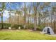 Large backyard featuring mature trees, a hammock, fire pit, and fenced border at 6917 Tanner Hall Blvd, Hanahan, SC 29410