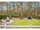 Backyard showing fire pit, golf net, hammock, and privacy fence among the mature trees at 6917 Tanner Hall Blvd, Hanahan, SC 29410
