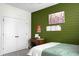 Bedroom featuring a green accent wall, ample closet space, and decorative wall decor at 6917 Tanner Hall Blvd, Hanahan, SC 29410