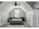 This attic bedroom features angled ceilings, a neutral palette, and a cozy seating area at 6917 Tanner Hall Blvd, Hanahan, SC 29410