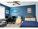 This bedroom features a surfboard accent, comfy seating, and decor against a blue wall at 6917 Tanner Hall Blvd, Hanahan, SC 29410