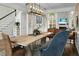 Open-concept dining area with a large table, wicker chairs, and views into the living room with fireplace at 6917 Tanner Hall Blvd, Hanahan, SC 29410