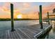 Tranquil waterfront view of a wooden dock during a vibrant sunset, offering a serene escape at 6917 Tanner Hall Blvd, Hanahan, SC 29410