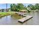 Scenic waterfront view with a covered dock and walkway, set against a backdrop of lush greenery and neighboring homes at 6917 Tanner Hall Blvd, Hanahan, SC 29410