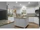 Bright kitchen featuring white cabinets, granite countertops, a center island and modern appliances at 6917 Tanner Hall Blvd, Hanahan, SC 29410