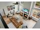 Open-concept living room features a fireplace, a large leather sofa, and plenty of natural light at 6917 Tanner Hall Blvd, Hanahan, SC 29410