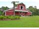 Community barn house with red siding, a large window on the second floor, and ample green space at 6934 Tanner Hall Blvd, Hanahan, SC 29410