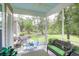 Inviting screened porch with wicker furniture, green cushions, ceiling with a light blue finish at 6934 Tanner Hall Blvd, Hanahan, SC 29410