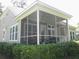 Rear exterior showing large screened-in porch, exterior fan, roof overhang and trimmed shrubbery at 6934 Tanner Hall Blvd, Hanahan, SC 29410