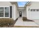 A close-up of the home's entryway showing the porch, door, black shutters, and manicured landscaping at 714 Battery Edge Dr, Summerville, SC 29486