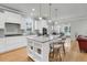 Modern kitchen featuring a large island with seating, white cabinets, stainless appliances, and hardwood floors at 714 Battery Edge Dr, Summerville, SC 29486