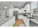 Bright kitchen features granite counters, stainless appliances, white cabinetry, and hardwood floors at 714 Battery Edge Dr, Summerville, SC 29486