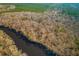 An aerial perspective showing the property near a serene river, bordered by bare trees under a clear sky at 7537 Parkers Ferry Rd, Adams Run, SC 29426