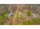An aerial view of the property featuring outbuildings, a winding dirt path, and plenty of trees and natural surroundings at 7537 Parkers Ferry Rd, Adams Run, SC 29426