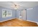 Bedroom featuring hardwood floors, a ceiling fan, and a bathroom with sliding door at 7537 Parkers Ferry Rd, Adams Run, SC 29426