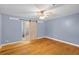 Bedroom featuring hardwood floors, a ceiling fan, and a bathroom with sliding door at 7537 Parkers Ferry Rd, Adams Run, SC 29426