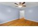Bright bedroom showcasing hardwood floors, ceiling fan, light-blue walls and closet with shelves at 7537 Parkers Ferry Rd, Adams Run, SC 29426