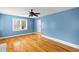 Light-filled bedroom featuring hardwood floors and bright blue walls at 7537 Parkers Ferry Rd, Adams Run, SC 29426