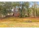 Charming brick two-story home surrounded by mature trees, featuring a cozy covered porch and natural light at 7537 Parkers Ferry Rd, Adams Run, SC 29426