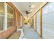 Long, enclosed patio featuring brick walls, many windows, ceiling fans and access to the yard at 7537 Parkers Ferry Rd, Adams Run, SC 29426