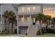 Charming two-story home with covered porch and well-manicured landscaping with palm trees at 775 Forrest Dr, Charleston, SC 29492