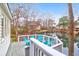 Backyard deck with blue Adirondack chairs overlooking a tranquil pond and surrounding trees and houses at 783 Lake Frances Dr, Charleston, SC 29412
