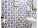 Stylish half bathroom features patterned wallpaper and a modern sink with a white basin at 783 Lake Frances Dr, Charleston, SC 29412
